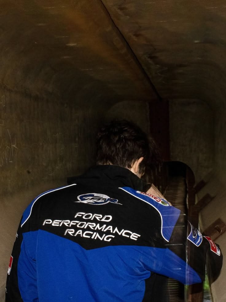 Jaqueta Ford Performance Racing azul e preta vista de costas, num túnel