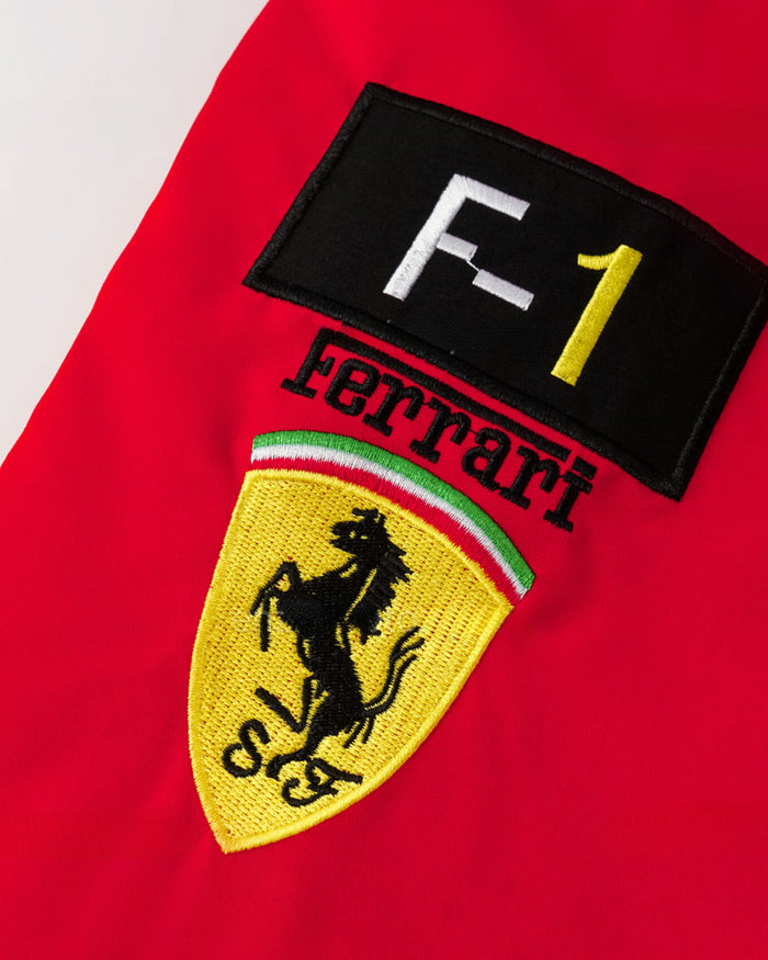 Manga com patch F-1 preto, nome bordado em arco e escudo amarelo